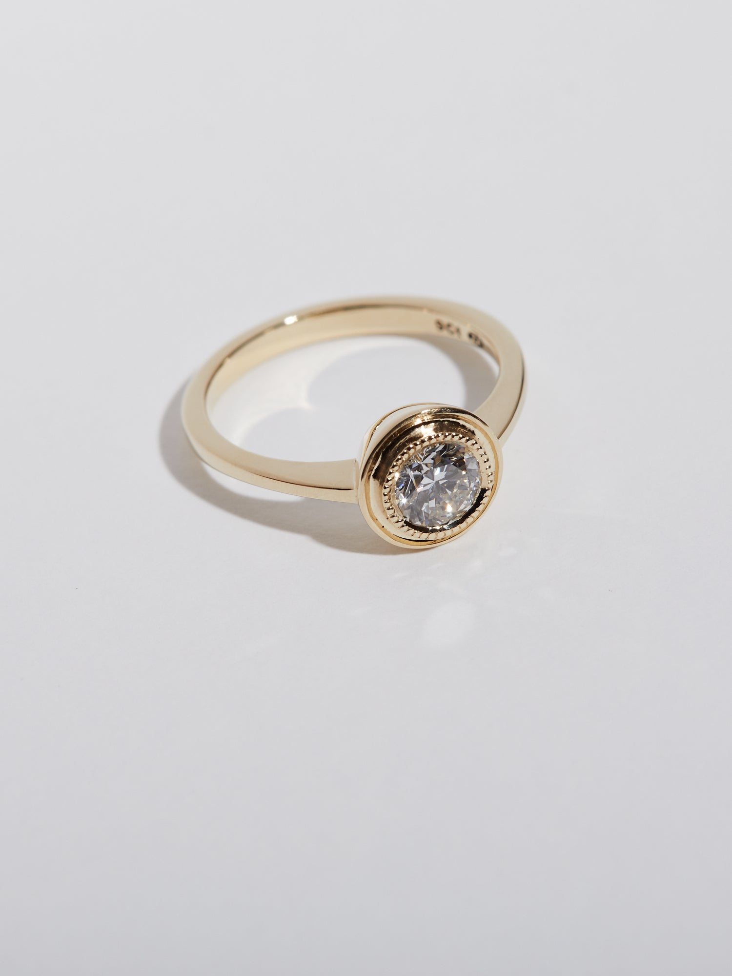 0.62ct Round diamond with millgrain halo solitaire.