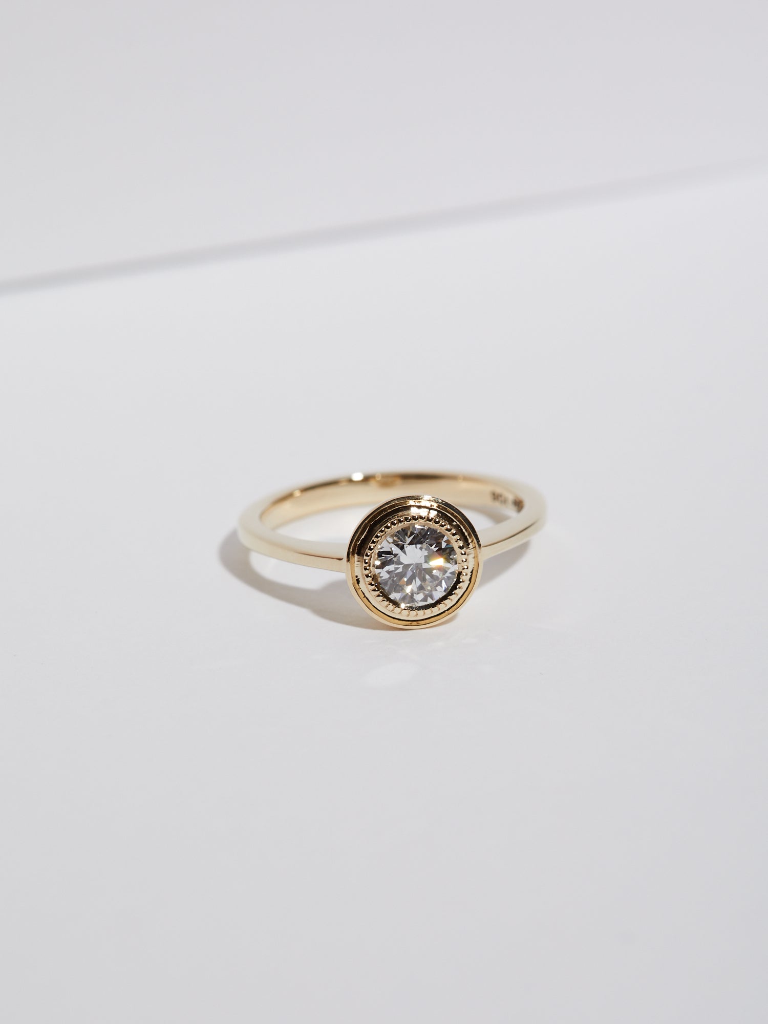 0.62ct Round diamond with millgrain halo solitaire.
